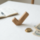 Wooden checkmark symbol on a white tablecloth near coins, Japanese yen bills, and an open notebook with handwritten notes.