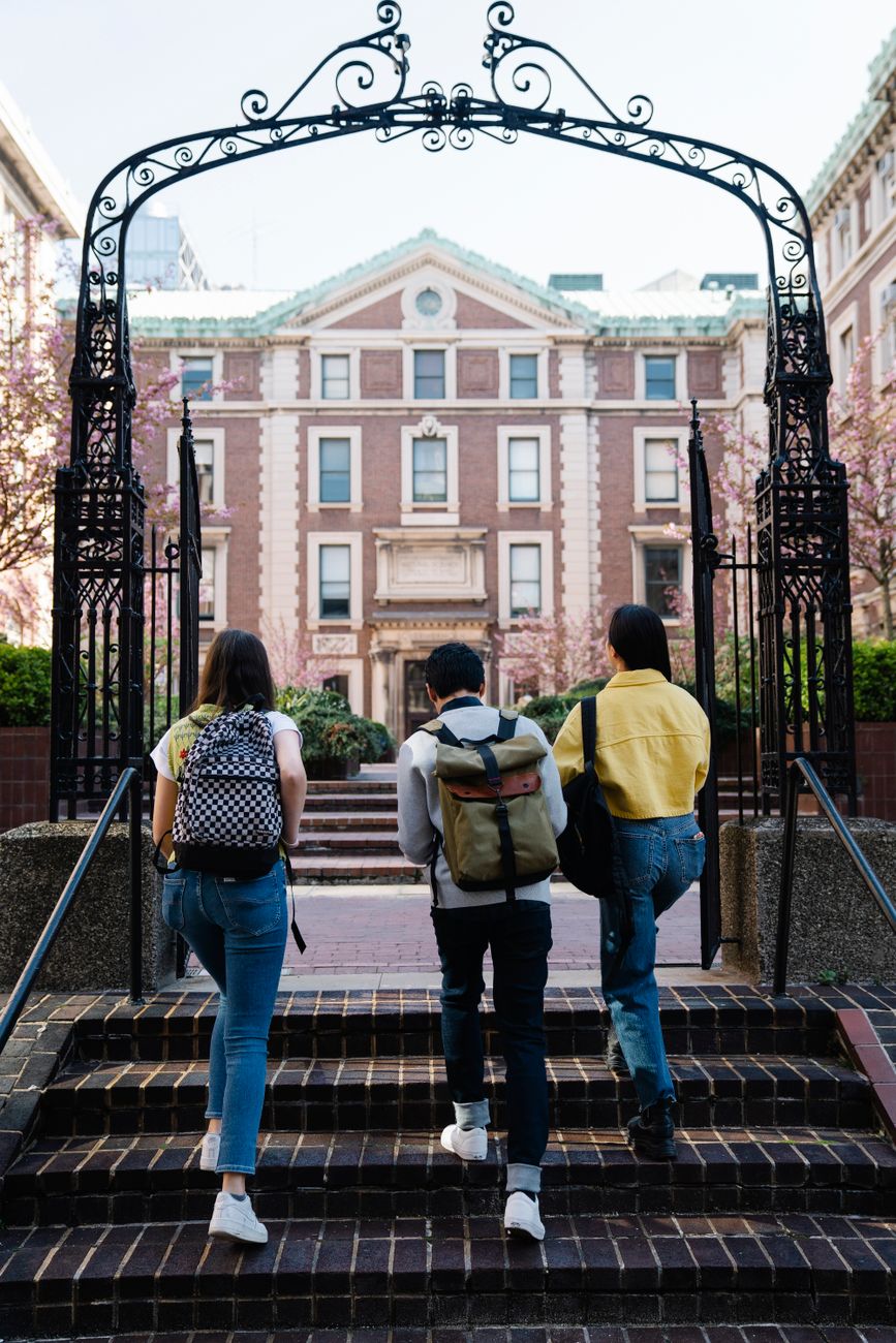 back view of people walking into a campus